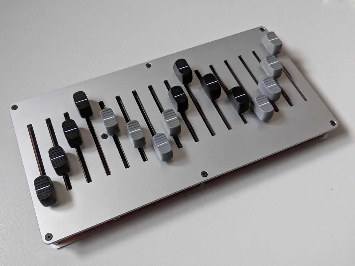 16n faderbank controller, sixteen faders in a silver panel, seen from above at an angle