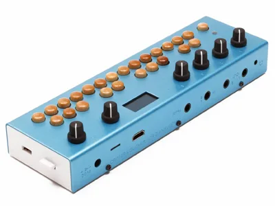 Original Organelle with a blue case, wooden keys, black knobs and an OLED screen, seen from above at an angle