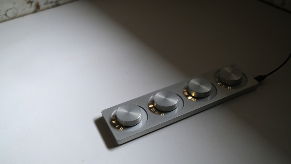 monome arc, a four-encoder controller with ring LEDs around each knob, connected by a USB cable